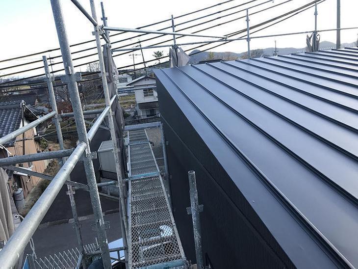 片流れの屋根にガルバ鋼板を施工しています。担当：森井
