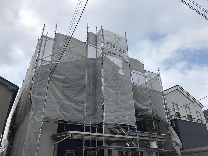 屋根・外壁工事のため足場を組みました。塗料やホコリなどが飛散しにくいように養生シートも貼っています。担当：高田