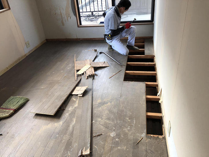 洋室の床をめくっています。垂木の上に直で貼ってありました。今回は垂木は再利用して、12ｍｍのベニヤ板を「捨て貼り」してから新しいフロアを貼ります。担当：中島凌太