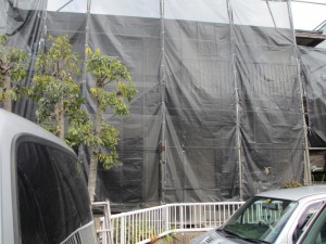 施工中：家の周りに足場を立て、ﾒｯｼｭｼｰﾄで覆います