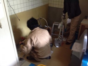 設備屋さんが新しいキッチンの図面を見ながら配管工事をしています。