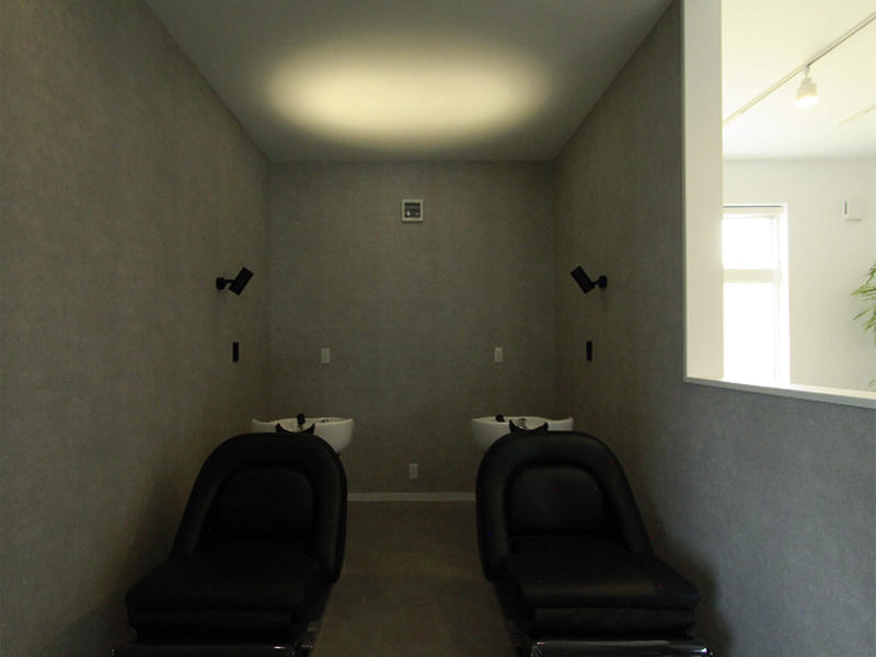 草津市 STORY様　シャンプースペースはコンクリート調で少し暗めのトーンに。スポットライトを動かせるので天井や壁の照らし方も自由自在で、また一味違う空間になります｜滋賀や大阪で店舗リフォームなら匠工房